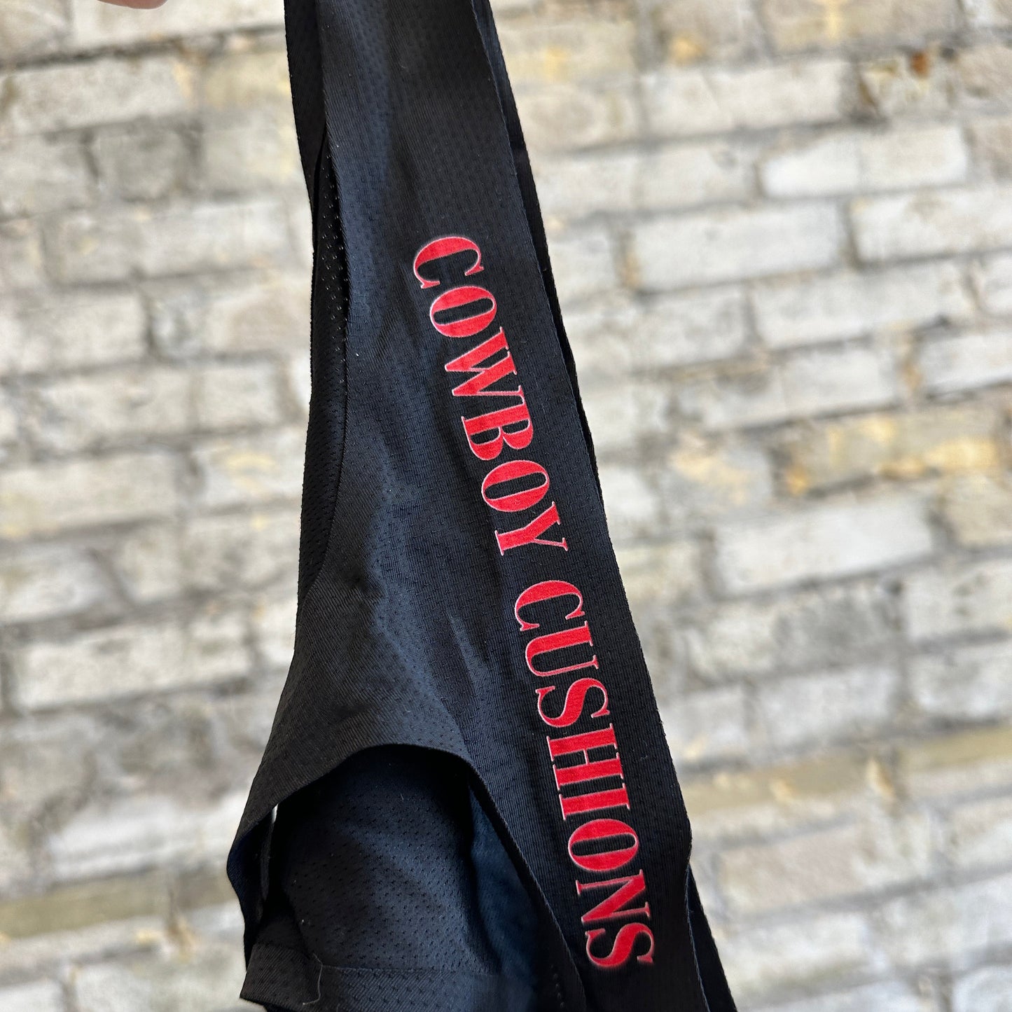 1 black thong underwear featuring the 'COWBOY CUSHIONS' logo. The item is displayed on a beige textured surface.