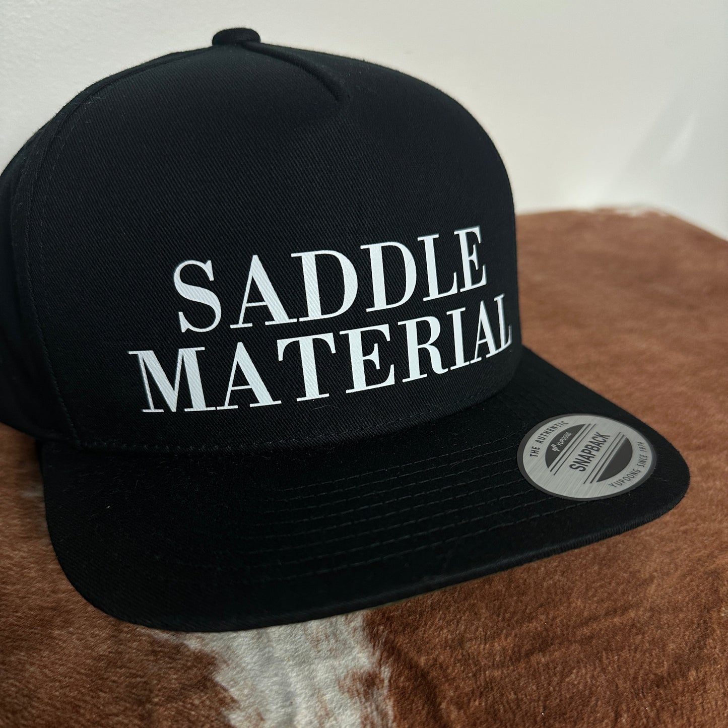 SADDLE MATERIAL TRUCKER HAT